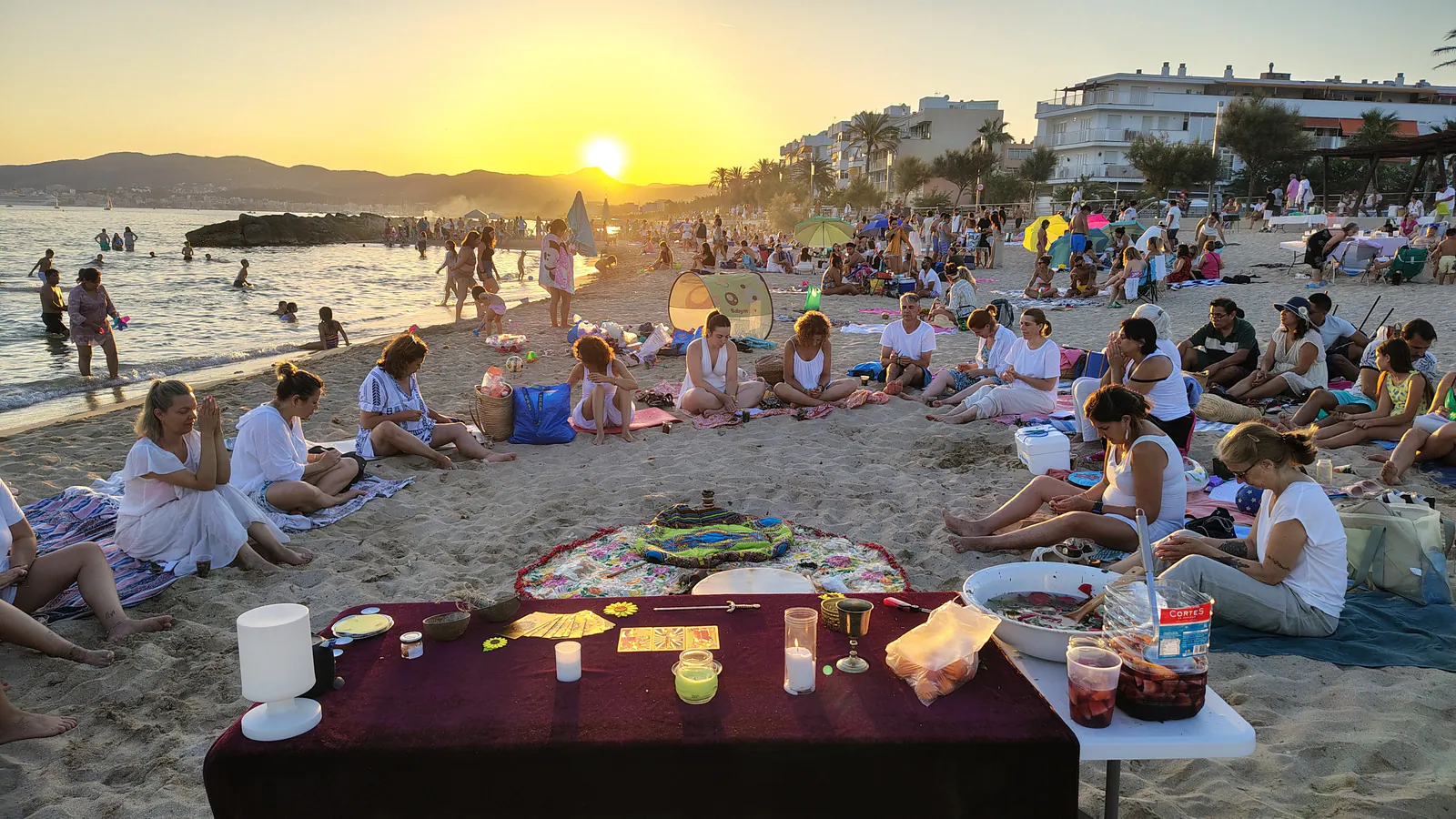 Encuentro grupal de meditación y ritual junto al mar al atardecer