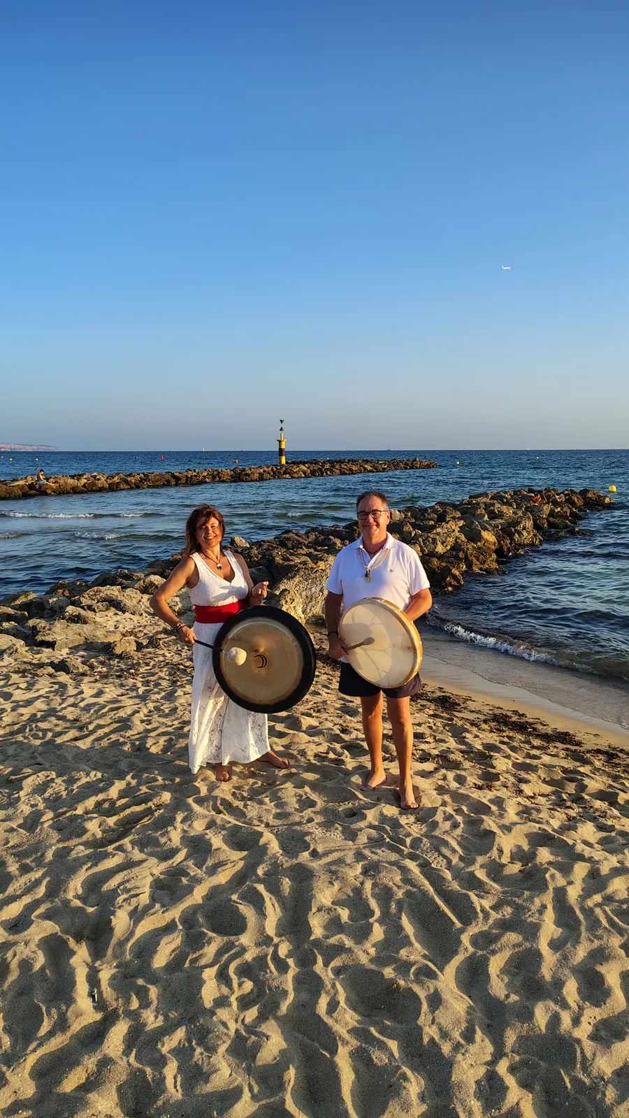 Xisco y una participante con sus gongs en la playa