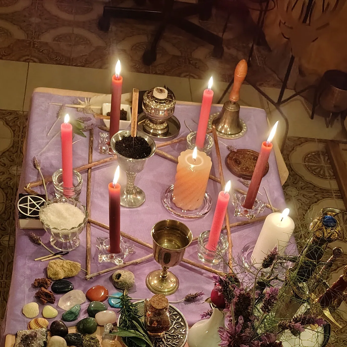Altar preparado para un ritual Wicca de Beltane, con velas, hierbas y flores
